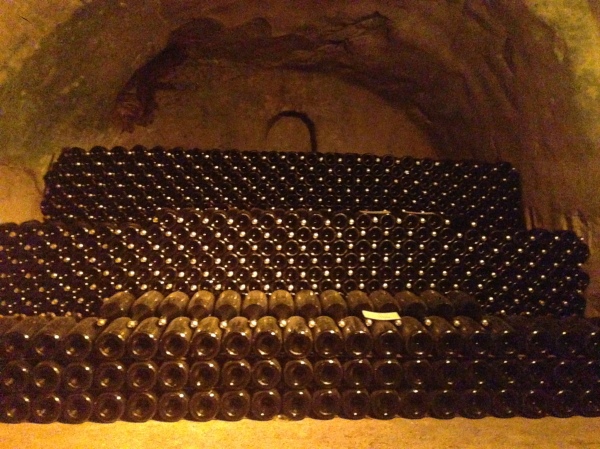 Champagne bottles lying on their sides during the aging process.